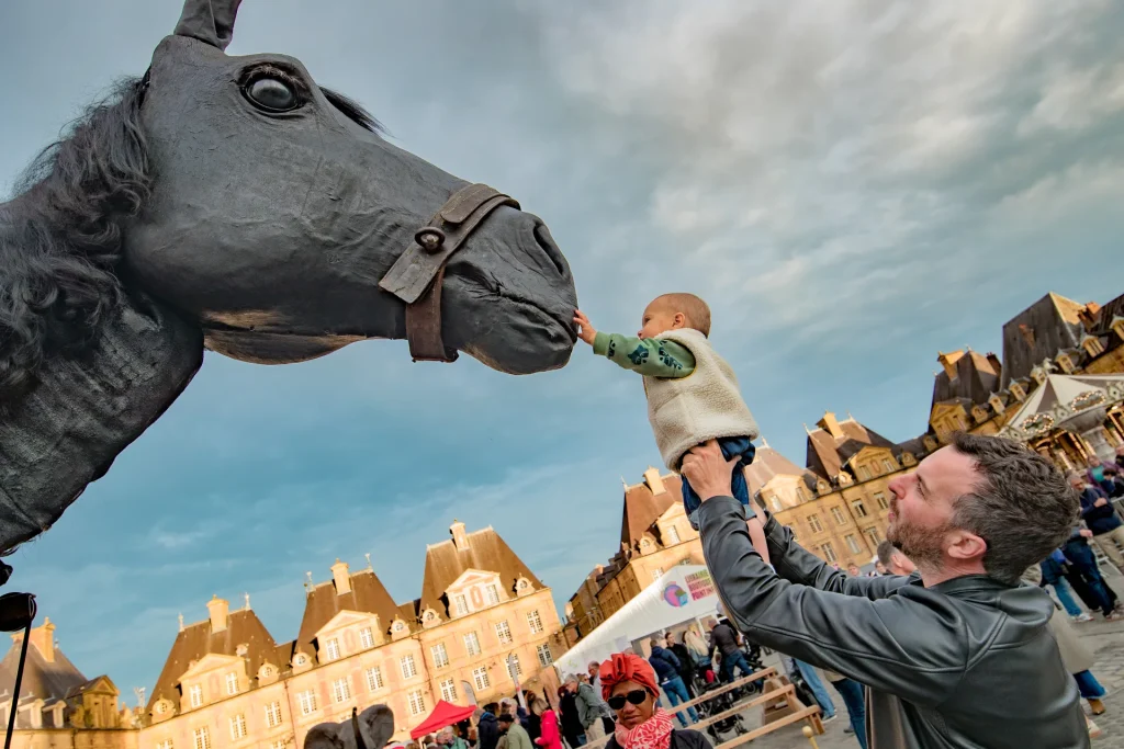 scène de rue lors du Festival mondial des théâtres de marionnettes 2025 place Ducale à Charleville-Mézières dans les Ardennes - Cheval et enfant