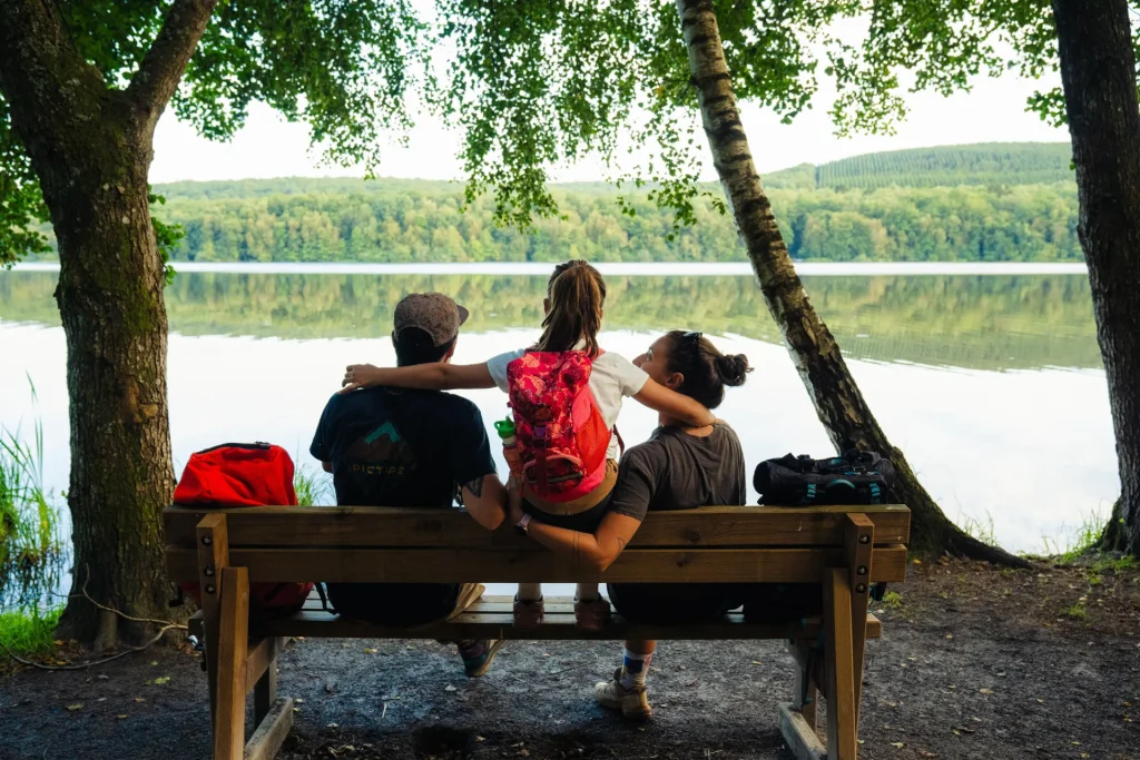 Famille sur un banc sur un sentier de randonnée au lac des Vieilles Forges dans les Ardennes